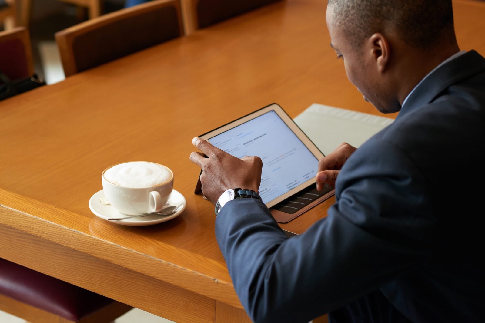 Un lecteur consulte ses e-mails et ses livres numériques attablé dans un café.